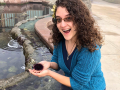 Jazmyne Gill holds a sea urchin over a small body of water